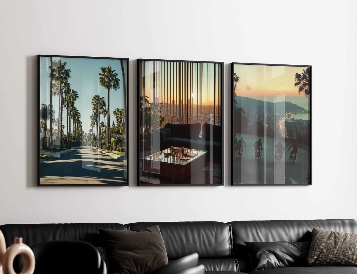Vintage Cityscape Poster Set of 3 featuring framed digital wall art with palm trees and sunset views above a black sofa, modern living room décor, Haus of Prints.