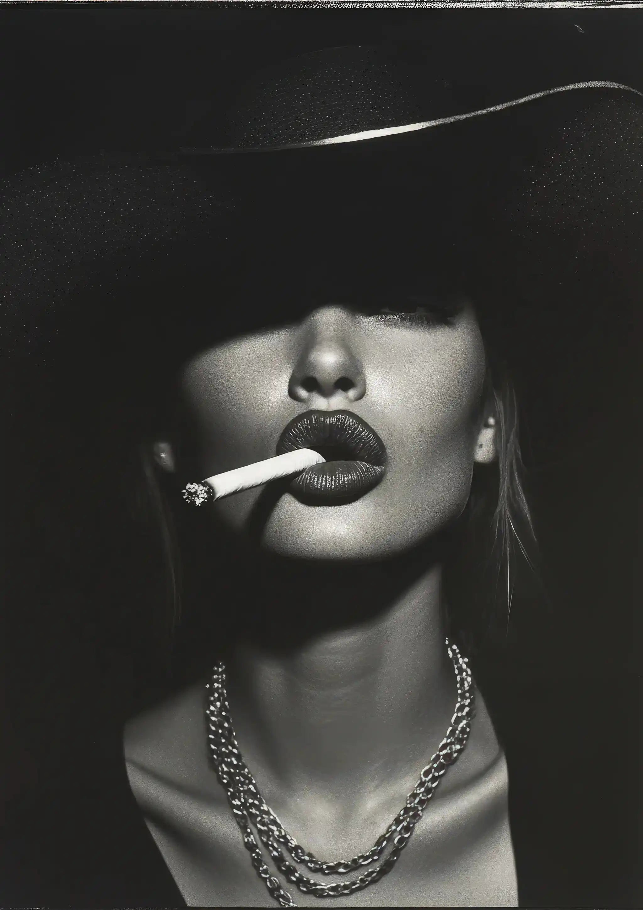 Black and white portrait of a woman wearing a wide-brimmed hat and layered necklaces, smoking a cigarette.